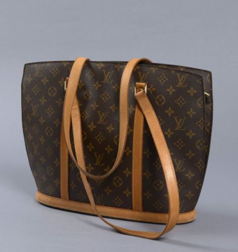 Louis VUITTON, Babylone en toile monogram, deux anses en cuir naturel. Intérieur en alcantara beige avec trois poches dont une zippée. Légère patine d'usage, marque de stylo à l'intérieur, très bon état. 30,5 x 41 cm.