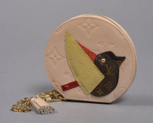 Louis VUITTON, Porte monnaie en monogram rose clair vernis à décor en application de différents monogram formant un oiseau, pompon et garnitures en métal doré. Diam.: 11 cm. Excellent état.