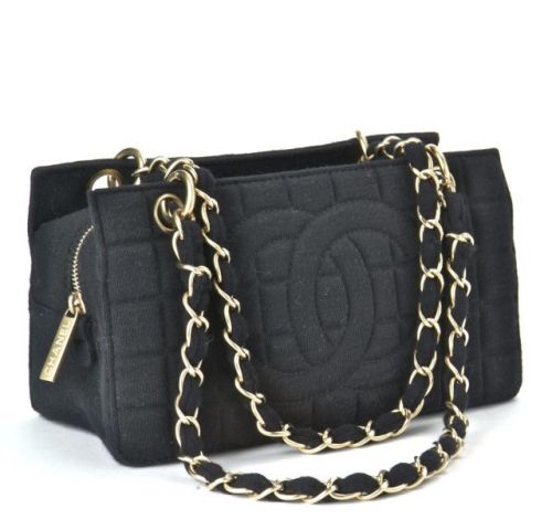 CHANEL, Shopping damassé en jersey noir, deux anses en chaîne dorée mate, trois compartiments dont une zippée, une poche intérieure zippée avec sa carte d'authenticité et livret. Excellent état.