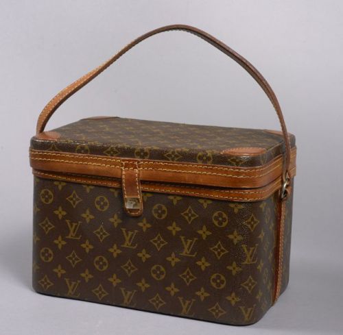 Louis VUITTON, Grand vanity case rigide en toile Monogram et cuir naturel, anse bandoulière, fermoir pivotant. Intérieur en toile beige et fond en plastique transparent, miroir sous le couvercle, trois emplacements en lanière de cuir naturel pour flacons,