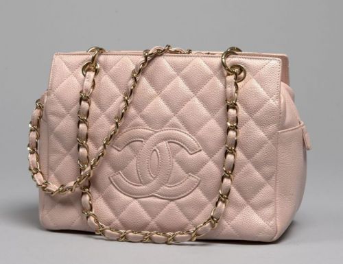 CHANEL, Sac en cuir caviar rose dragée matelassé, deux anses en métal doré entrelacées de cuir à la couleur, trois compartiments et deux poches à l'intérieur. 19 x 28 cm. Petites salissures et patine d'usage mais bel état.