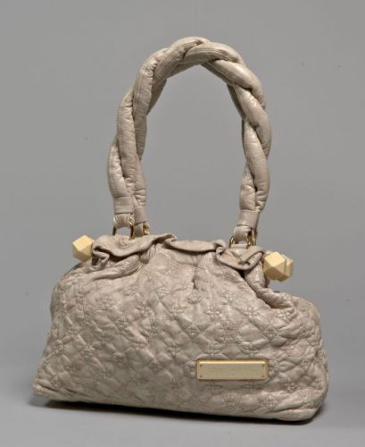 Louis VUITTON, Edition limitée, Sac d'épaule Olympe Stratus en cuir Monogram beige souple agrémenté d'une plaque en métal doré et bakélite ivoire. Double anse tressée en cuir à la couleur, garniture en métal doré. Fermeture rigidifiée par deux barres agré