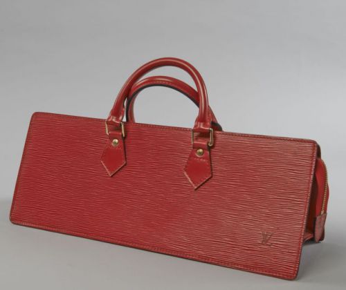 Louis VUITTON, Sac Triangle en cuir épi rouge et cuir lisse à la couleur, deux anses portées main, fermeture par zip, intérieur en cuir noir à une poche plaquée. Long.: 40 cm. Quelques rayures sous la base sinon très bel état général.
