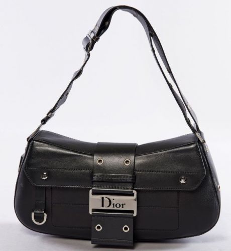 Christian DIOR, Modèle Street chic en cuir noir. Bon état. Une large anse réglable. Fermeture aimantée en métal siglé. Usure et patine d'usage, intérieur avec poche zippée. Avec son étui de protection.14 x 30 cm.