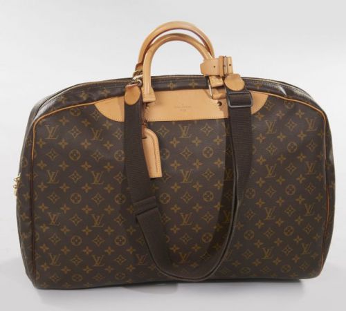 Louis VUITTON, Sac valise en toile Monogram. Deux anses portées main en cuir naturel et une anse bandoulière en tissu. Large fermeture zippée. Intérieur en toile beige comportant une grande poche plaquée. Une grande poche amovible en toile marron et ouvra