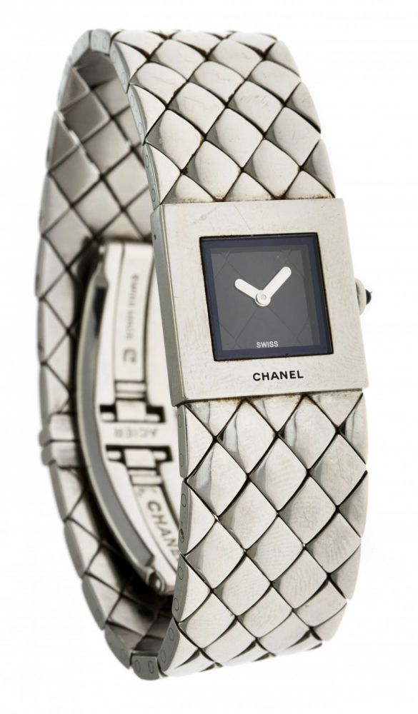 CHANEL,Matelassé, n° F.D. 87031,Vers 1990,Montre bracelet de dame en acier,Boîtier: carré, signé,Cadran: noir matelassé,Mouvement: quartz,Bracelet: en acier à motif matelassés,Boucle: déployante, signée,Dim.: 19 x 19 mm,Tour de poignet. 160 mm,A stainless