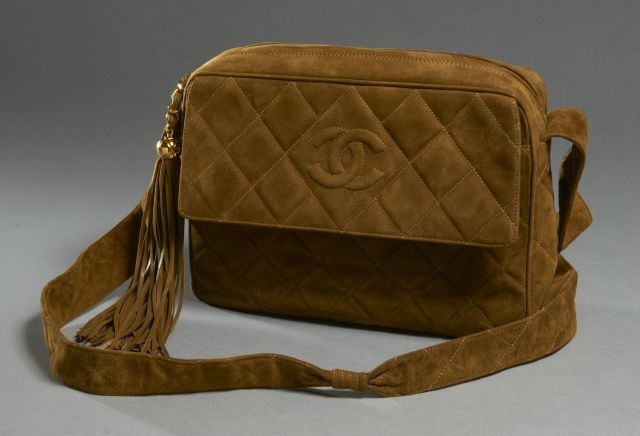 CHANEL Sac d'épaule en veau velours matelassé brun avec poche avant siglée et ponpon en lanières de cuir, 2 poches intérieures dont une zippée, bon état, carte d'authenticité.