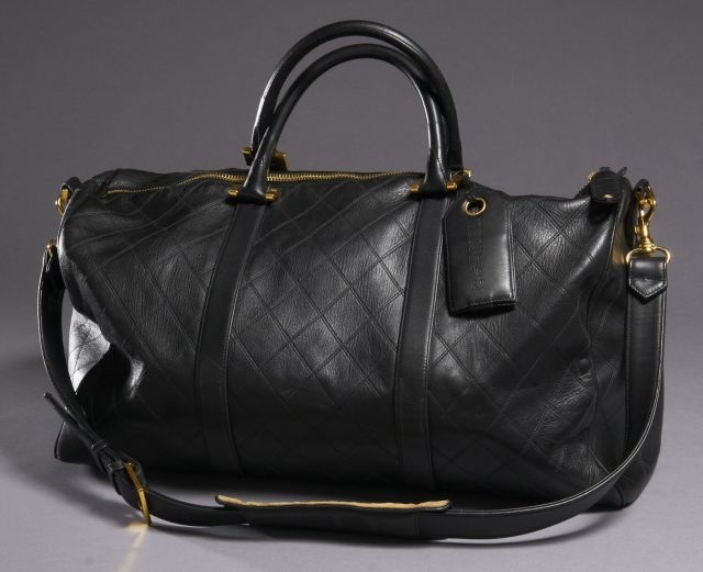 CHANEL Sac de voyage Magnifique! en cuir matelassé noir avec porte-adresse et bandoulière, garnitures en métal doré et 2 poches intérieures zippées. Très bon état.