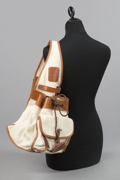 MOSCHINO LOT comprenant un petit SAC à rabat en toile et cuir noir agrémenté d'une anse bandoulière sangle chiffrée en métal doré, un SAC d'épaule en toile écrue et cuir naturel et une CEINTURE chaîne en métal doré rehaussée de breloques