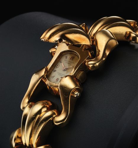 PATEK PHILIPPE REF. 2100 LADY'S.RETAILED BY SERPICO Y LAINO, CARACAS.Patek Philippe Cie, Genève, No. 948040, case No. 647636.Ref. 2100. Made circa 1945..Very fine and unusual, oval 18K yellow gold lady's wristwatch with concealed dial, inserted in a wid