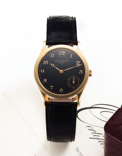 PATEK PHILIPPE REF. 5026 YELLOW GOLD.Patek Philippe, Genève, Calatrava, No. 4963389. Ref. 5026J..Made in 1997..Very fine and rare, self-winding, water-resistant, 18K yellow gold.wristwatch with offset seconds and an 18K yellow gold Patek.Philippe buckle. 
