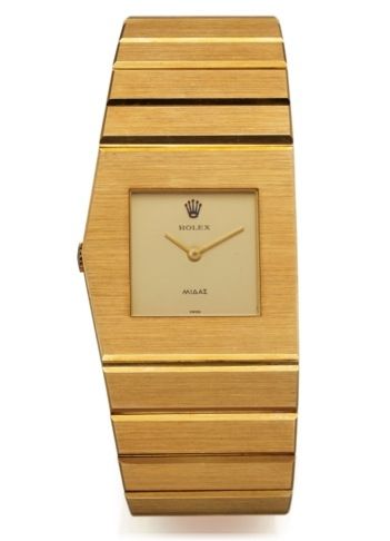 ROLEX REF. 3580J, KING MIDAS.[NEW, OLD STOCK].Rolex, No. 1164, case No. 4019336, Ref. 3580J. Made in the.late 1970s..Fine and elegant, asymmetrical, left-handed, heavy 18K.yellow gold wristwatch with an integral 18K yellow gold.Rolex link bracelet and con