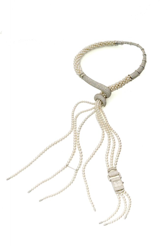 PIAGET, MISS PROTOCOLE, WHITE GOLD AND DIAMOND NECKLACE WITH WATCH Rare and impressive, quartz, 18k white gold and diamond and peal necklace with a detachable watch/brooch.