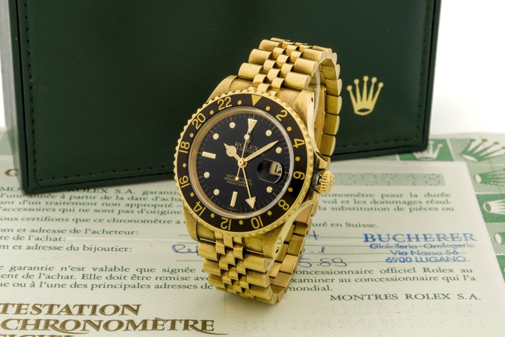 ROLEX REF. 16758 GMT-MASTER YELLOW GOLD BLACK TRANSITIONAL DIAL Very fine and rare, two-time zone, center seconds, self-winding, water-resistant, 18K yellow gold wristwatch with date.