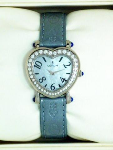Corum, Ref. 24.183.47. Produced in the 1990's, sold on January 15, 2003..Fine, heart-shaped, stainless steel, diamonds and cabochon sapphire lady's quartz wristwatch with a satin_ blue leather strap engraved with the logo and a stainless steel Corum buckl