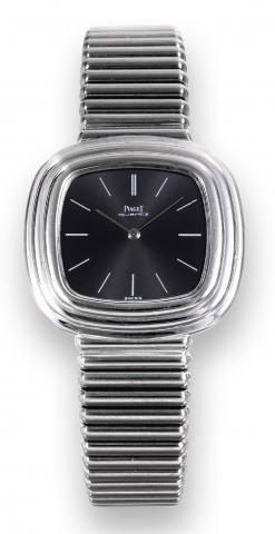 Piaget, Quartz.No. 299811, Ref. 75101 C.10. Sold on February 6th, 1978..Fine, heavy, cushion-shaped, waterresistant.18K white gold quartz wristwatch.with an 18K white gold integral.Piaget link bracelet. Accompanied by.the original Piaget certificate and s