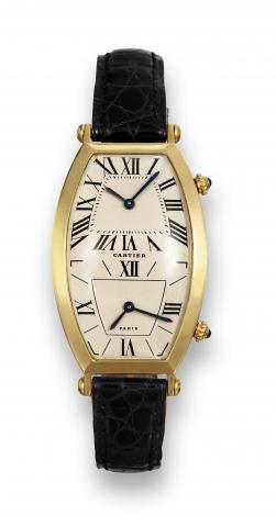 Cartier Two Time Zones.Cartier, Paris, case No. A 108218, Ref. 039-90. Made in the.1990's..Very fine and rare, large, tonneau-shaped, curved, waterresistant.two time zone, 18K yellow gold mid-size wristwatch.with a gold-plated Cartier buckle..To be sold w