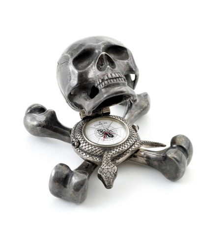 Jolly Roger No. 1.Corum, Jolly Roger, Ref. 677.993, No. 001..Made in a limited edition, circa 2000..Silver quartz form clock in the shape of a skull atop a snake.and crossbones, with concealed dial and alarm..To be sold without reserve