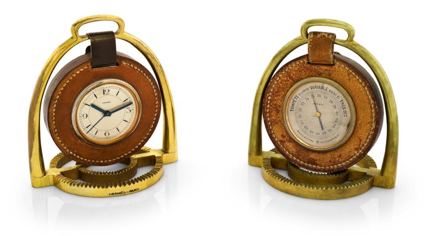HERMÈS PENDULETTE BAROMETER ÉTRIER.Hermès, Paris, Etrier, the movement by Pontifa-Audoine, Swiss. Made circa 1935..Fine and rare, 8-day going, gilt brass and leather stirrup-form desk clock with alarm and a matching aneroid barometer.Holosterique, proba