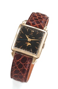 OMEGA REF. 3944. COSMIC BLACK DIAL YELLOW GOLD. Omega, No. 12877536, case No. 11116916, Ref. 3944.. Made circa 1951.. Very fine and rare, square, astronomic, 18K yellow gold. wristwatch with triple date, moon phases and an gold plated. Omega buckle.