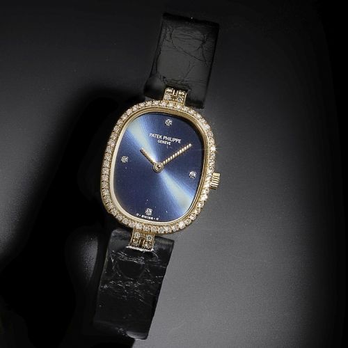 Patek Philippe. A lady's 18K gold and diamond set oval quartz wristwatch