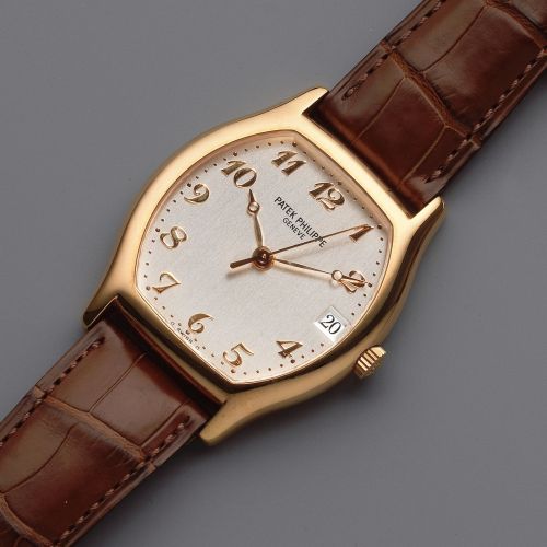 Patek Philippe. An 18K rose gold automatic calendar tonneau form wristwatch