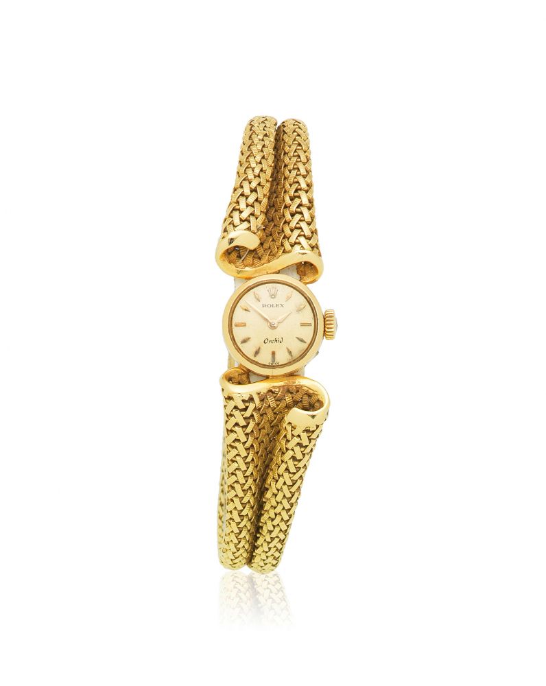 Rolex. A lady's 18K gold manual wind bracelet watch with unusual bracelet