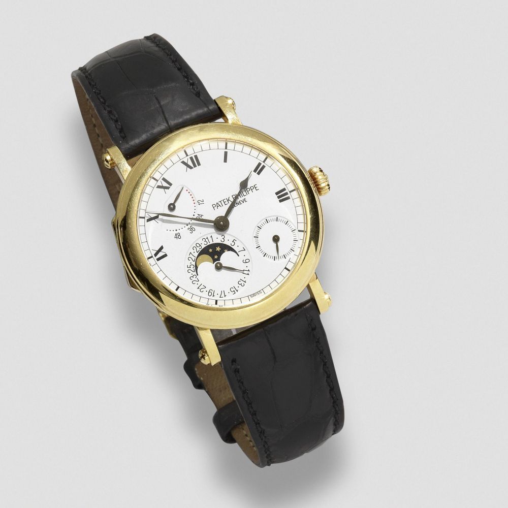 Patek Philippe. An 18K gold automatic calendar wristwatch with moon phase and power reserve