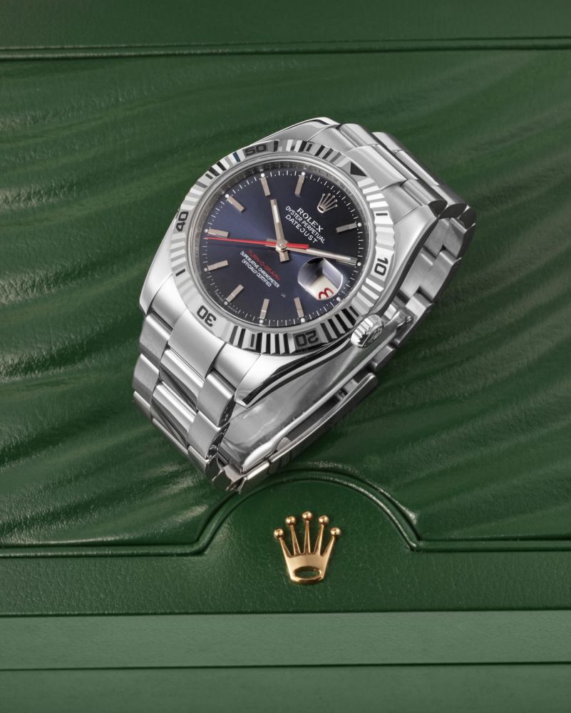 ROLEX | REF. 116264 TURN-O-GRAPH, AN ATTRACTIVE STAINLESS STEEL BRACELET WATCH WITH WHITE GOLD BEZEL, BLUE DIAL AND DATE, CIRCA 2004