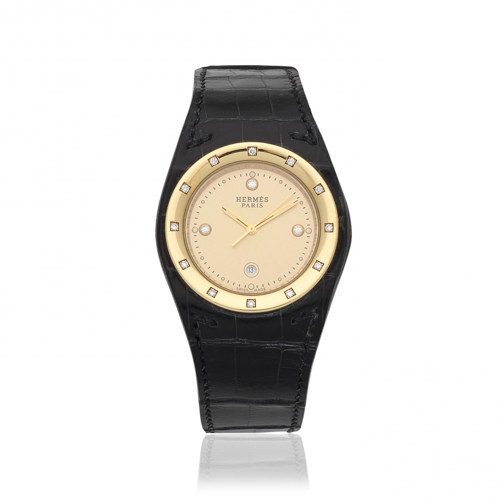 Hermès. An 18K gold diamond set quartz calendar wristwatch