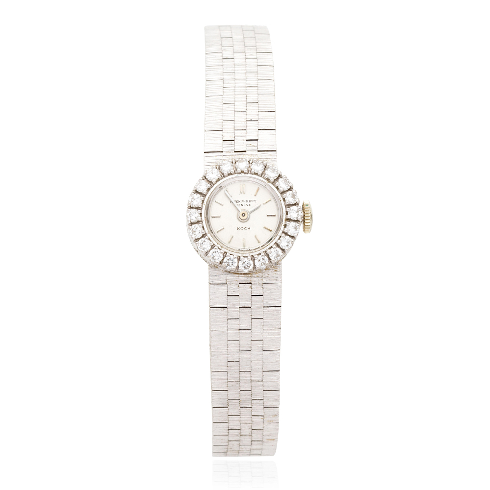 Patek Philippe. A lady's 18K white gold and diamond set manual wind bracelet watch retailed by Koch