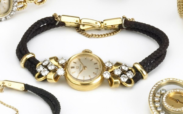 Omega. A lady's 18k gold and diamond set wristwatch on cord strap