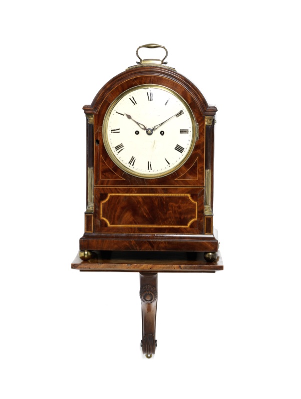 An early 19th century inlaid mahogany clock with wall bracket