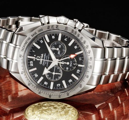 Omega. A stainless steel automatic chronograph calendar twin time zone bracelet watch together with fitted box and papers