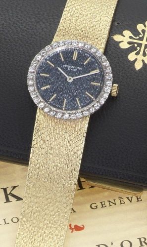 Patek Philippe. A lady's 18ct gold and diamond set bracelet watch together with Extract from Archives