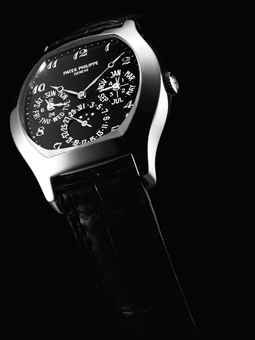PATEK PHILIPPE. A VERY FINE AND RARE 18K WHITE GOLD TONNEAU-SHAPED AUTOMATIC PERPETUAL CALENDAR WRISTWATCH WITH MOON PHASES, LEAP YEAR AND 24 HOUR INDICATION, BLACK DIAL, BREGUET NUMERALS AND ORIGINAL CERTIFICATE