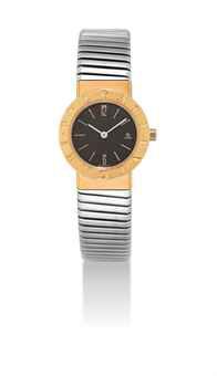 BULGARI. A LADY'S 18K GOLD AND STAINLESS STEEL BANGLE WATCH WITH DATE