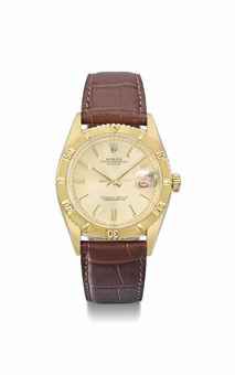 Rolex. An 18K gold automatic wristwatch with sweep centre seconds, alternate red and black date, Thunderbird bezel and champagne dial