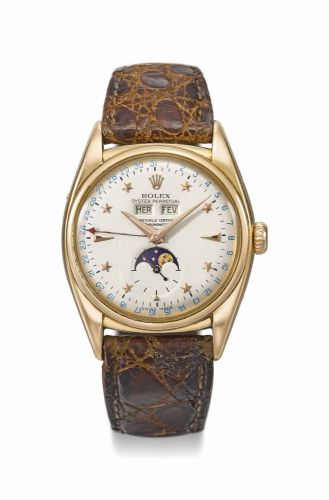 Rolex. A very rare and important 18K pink gold automatic triple calendar wristwatch with moon phases and star dial, service certificate, setting pin and box