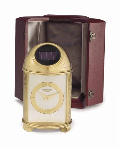 Patek Philippe. A Fine and Very Rare Gilt Brass Solar-Powered Dome Table Clock with Fitted Box b/b