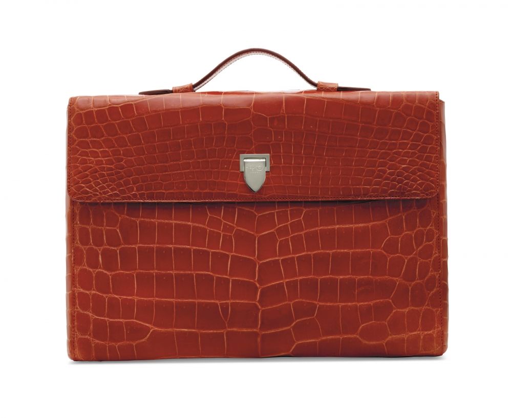 A SHINY RED ALLIGATOR CITY PORTFOLIO CASE WITH SILVER HARDWARE