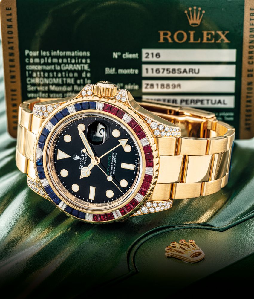 ROLEX. A FINE AND VERY RARE 18K GOLD, DIAMOND, SAPPHIRE AND RUBY-SET AUTOMATIC DUAL TIME WRISTWATCH WITH SWEEP CENTRE SECONDS, DATE AND BRACELET
