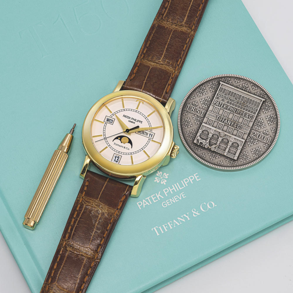 PATEK PHILIPPE. A RARE 18K GOLD LIMITED EDITION AUTOMATIC ANNUAL CALENDAR WRISTWATCH WITH SWEEP CENTRE SECONDS AND MOON PHASES, MADE TO CELEBRATE THE 150TH ANNIVERSARY OF THE RELATIONSHIP BETWEEN PATEK PHILIPPE AND TIFFANY CO.