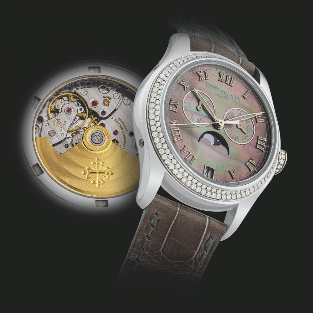 PATEK PHILIPPE. A LADY’S 18K WHITE GOLD AND DIAMOND-SET AUTOMATIC ANNUAL CALENDAR WRISTWATCH WITH MOON PHASES AND MOTHER-OF-PEARL DIAL