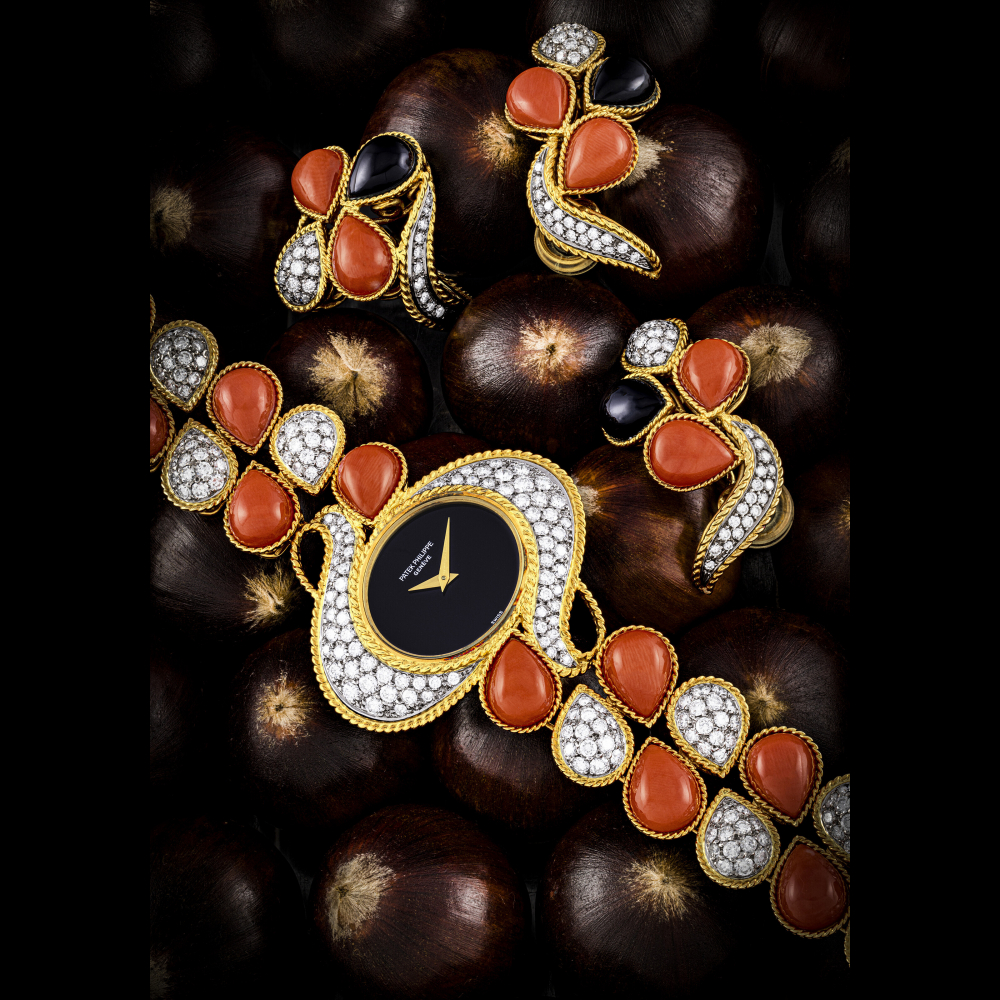 PATEK PHILIPPE. A VERY RARE AND IMPRESSIVE 18K GOLD CORAL AND DIAMOND-SET BRACELET WATCH WITH ONYX DIAL MATCHING EAR CLIPS AND RING