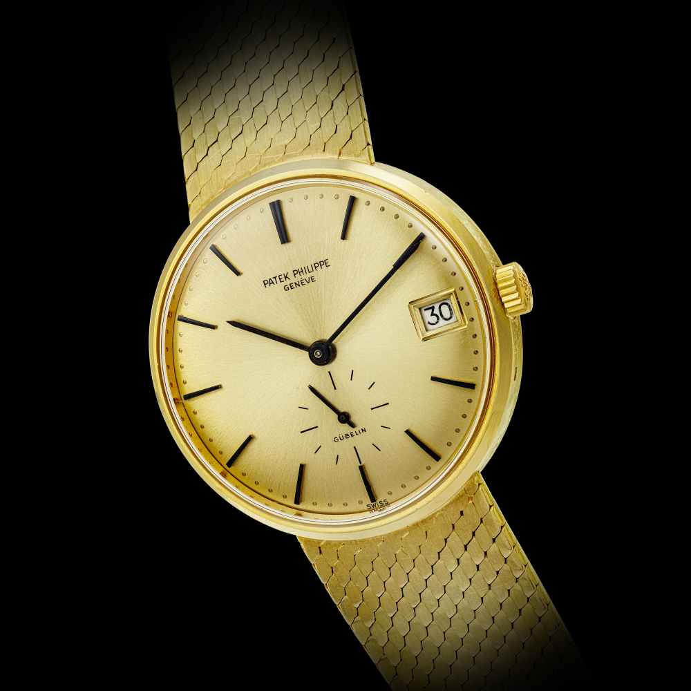 PATEK PHILIPPE. AN 18K GOLD AUTOMATIC BRACELET WATCH WITH DATE, RETAILED BY GÜBELIN