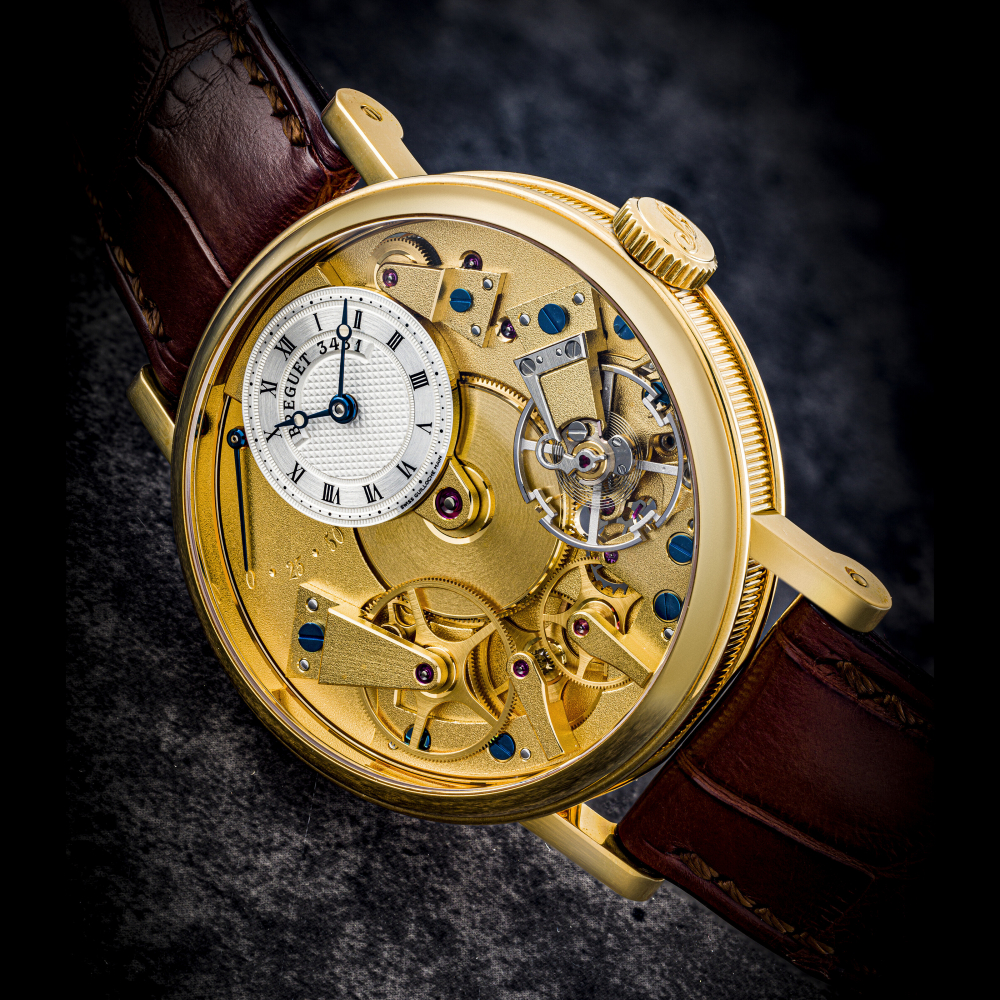 BREGUET. AN 18K GOLD SEMI-SKELETONISED WRISTWATCH WITH POWER RESERVE