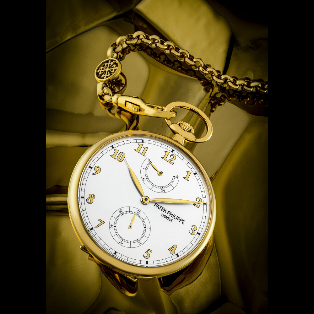 PATEK PHILIPPE. AN 18K GOLD OPEN-FACED KEYLESS LEVER POCKET WATCH WITH POWER RESERVE AND 18K CHAIN