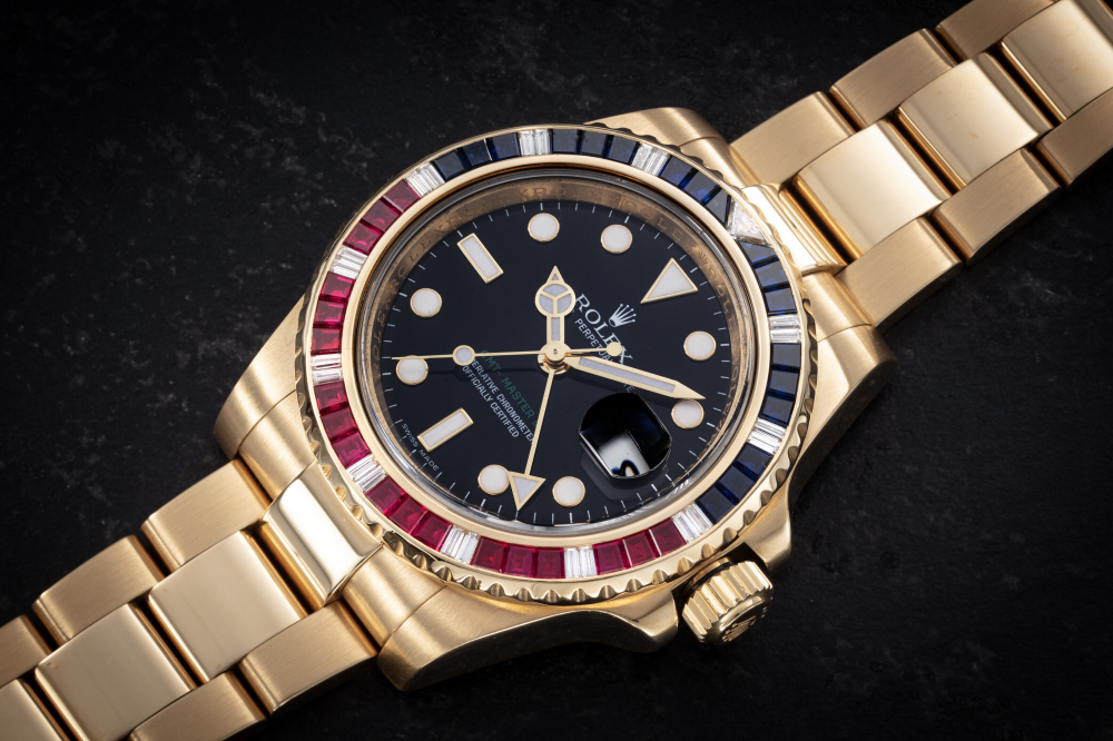 ROLEX, GMT-MASTER II SARU REF. 116748, A GOLD RUBY, SAPPHIRE, AND DIAMOND-SET DUAL TIME WRISTWATCH - CASE