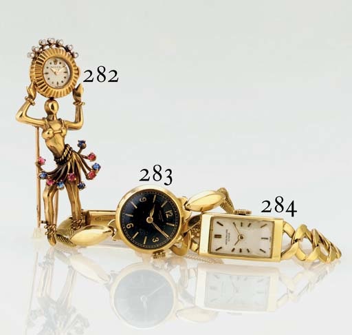 ROLEX. A RARE AND UNUSUAL 18K PINK GOLD, DIAMOND, RUBY AND SAPPHIRE BROOCH WATCH IN THE FORM OF A DANCER